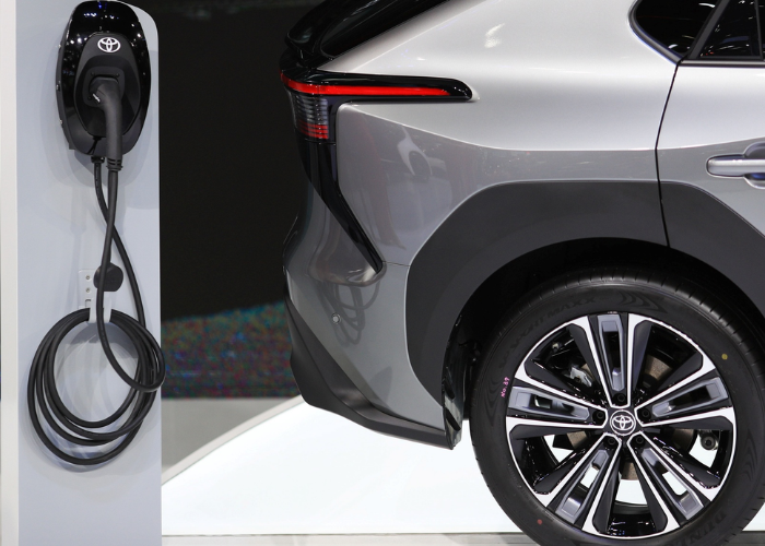 Silver Toyota SUV reversed towards an EV charger. showcasing hybrid vs plug-in hybrid