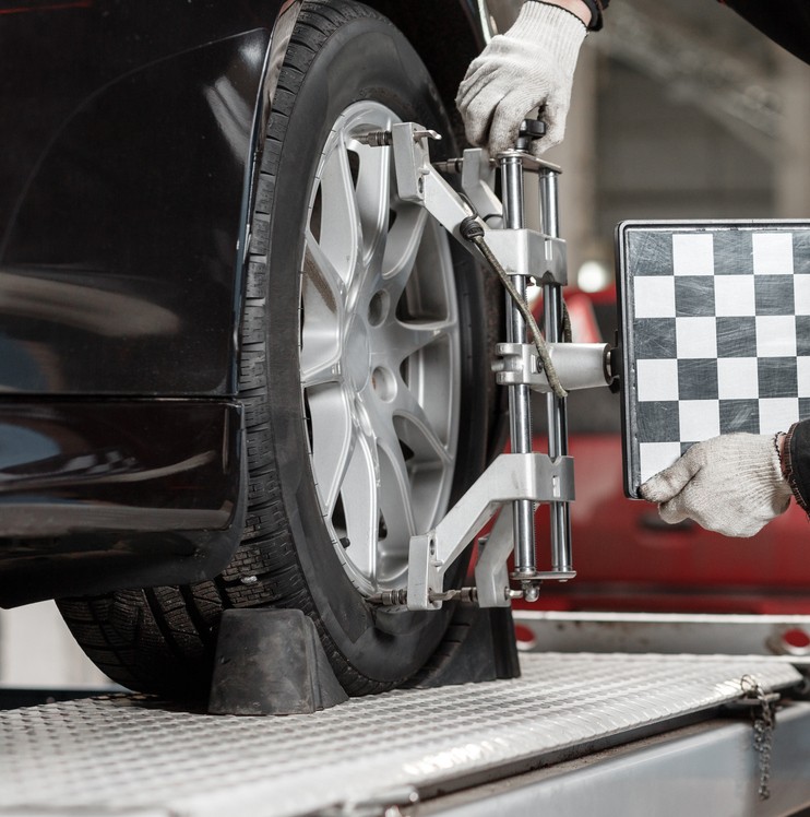 Mechanic performing a wheel alignment service in a garage
